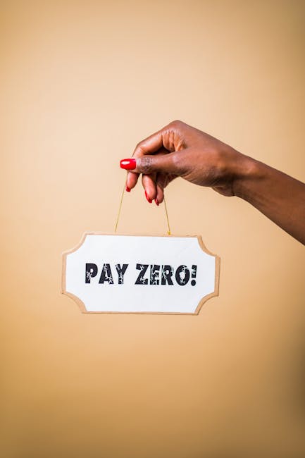 A close-up of a person's hand with neatly manicured fingernails and red nail polish holding a small, white, rectangular sign with rounded edges that reads 'PAY ZERO!'. The hand is positioned against a plain, beige background and is hanging the sign by a thin, golden string. The sign's message suggests a promotional or financial statement related to cost-free services, aligning with the themes of transparency and no hidden charges in domestic cleaning or surface maintenance. This image emphasizes clear communication and trust, core elements in the cleaning industry's focus on honest pricing and thorough sanitisation. Carpet Cleaners Harringay might use this image to promote their transparent quotes and reliable cleaning services.